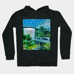 A roof waterfall with passing sky trains in Changi airport 1 Hoodie